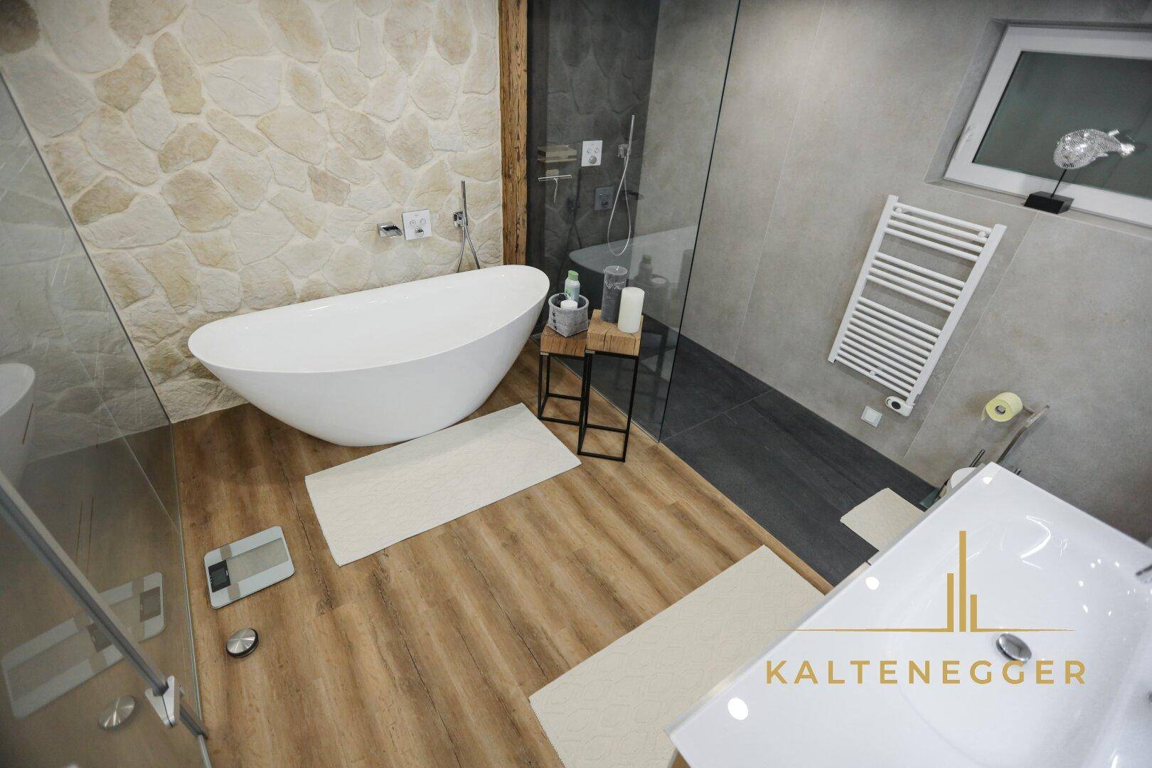 Geräumiges Badezimmer mit freistehender Wanne, Dusche und beheiztem Handtuchhalter.