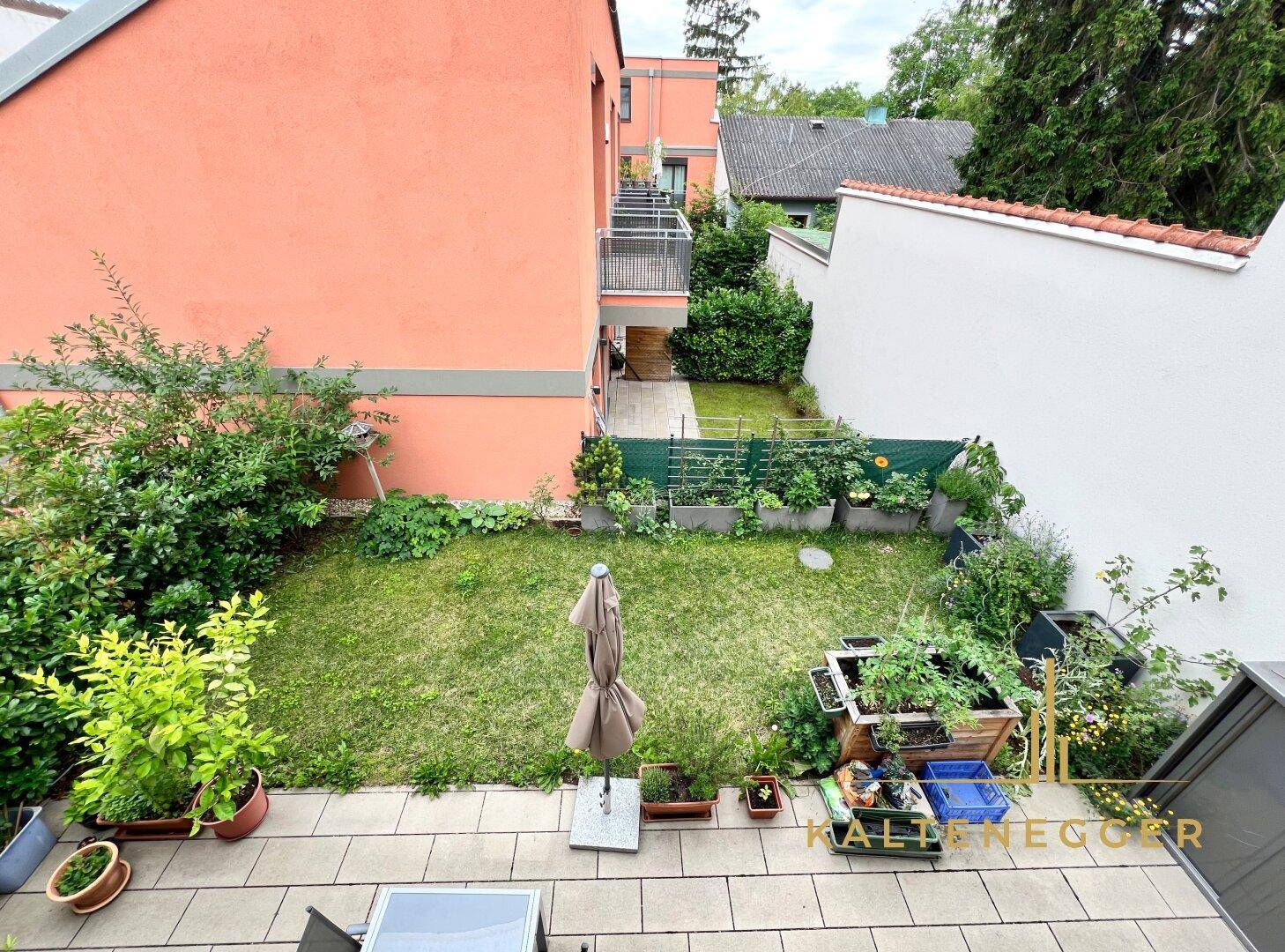 Blick aus Wohnzimmer und Terrasse in die Wohnhausanlage