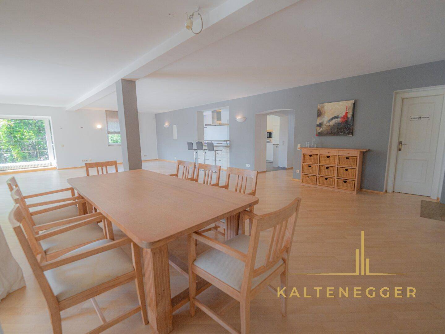 Geräumiger Essbereich mit großem Holztisch und Stühlen, integriert in einen offenen Wohnraum.