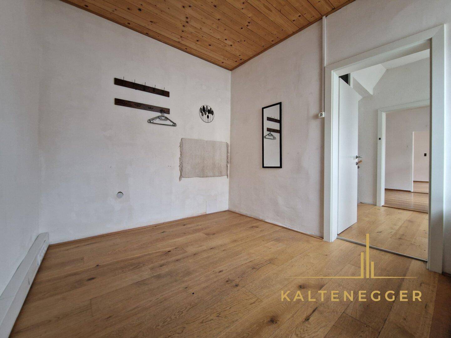 Gemütlicher Raum mit Holzboden und Holzdecke, ideal als Schlafzimmer oder Arbeitszimmer.