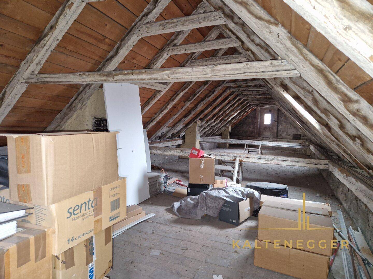Geräumiger Dachboden mit sichtbaren Holzbalken und viel Stauraum, bereit für Ausbau.
