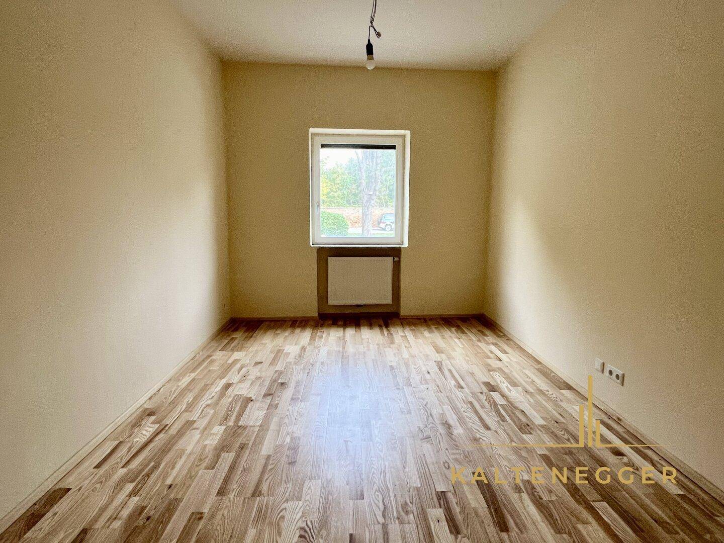 Ruhiges Zimmer mit Parkettboden und einem Fenster, ideal als Schlaf- oder Arbeitszimmer nutzbar.
