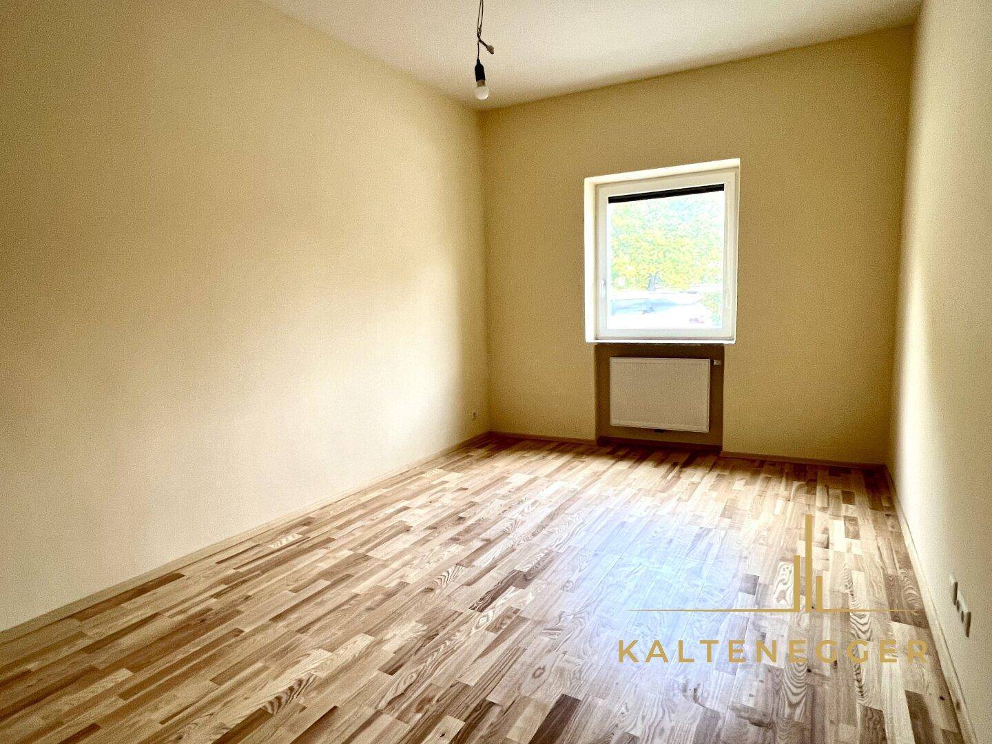 Gemütliches Zimmer mit Parkettboden und einem Fenster, perfekt für ein Kinderzimmer oder Büro.