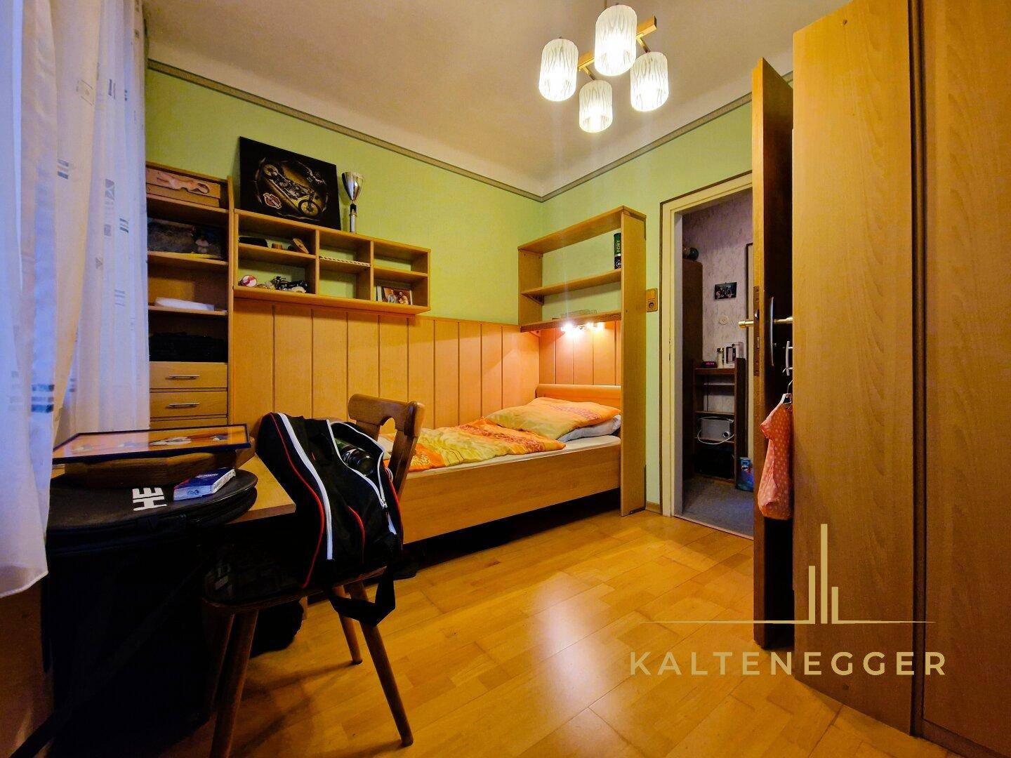 Kinderzimmer mit Holzmöbeln, Parkettboden und Fenster, das eine gemütliche Atmosphäre schafft.