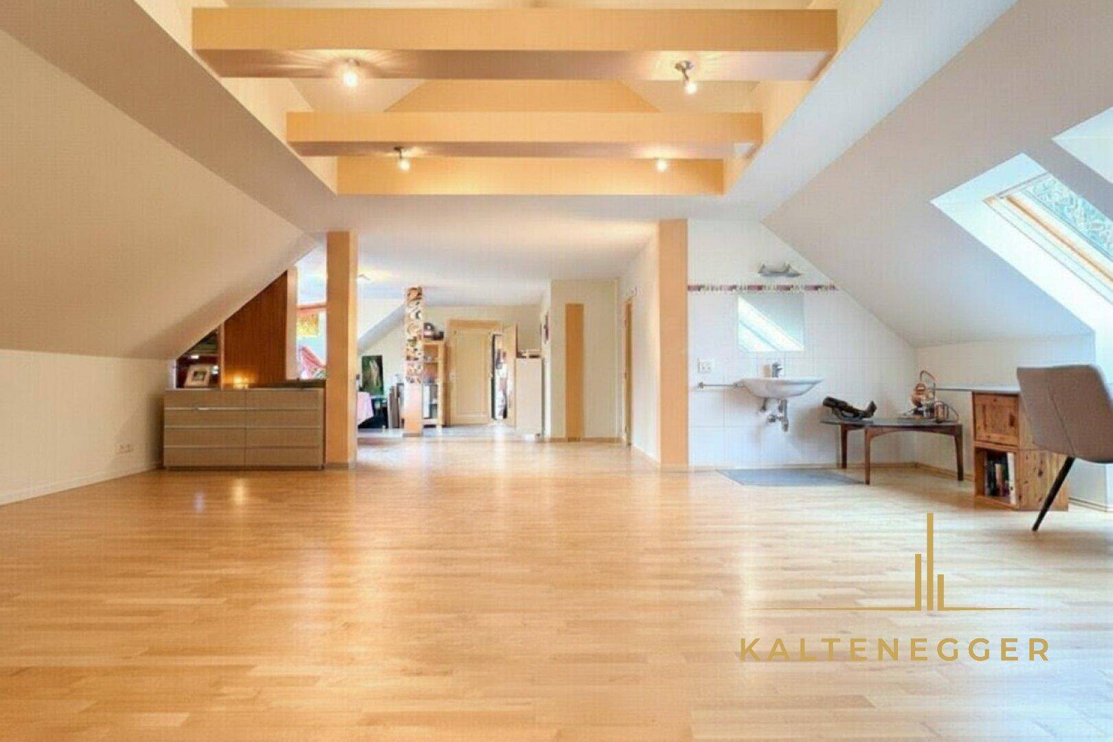 Heller Dachbodenbereich mit Holzboden, sichtbaren Balken und Dachfenstern.