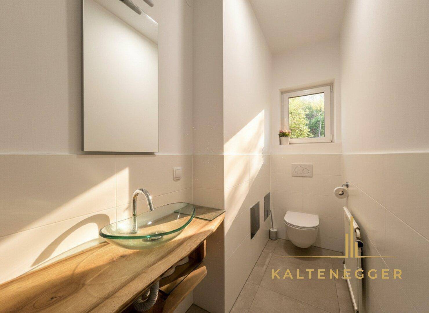 Modernes Gäste-WC mit Aufsatzwaschbecken, Wand-WC und Fenster.