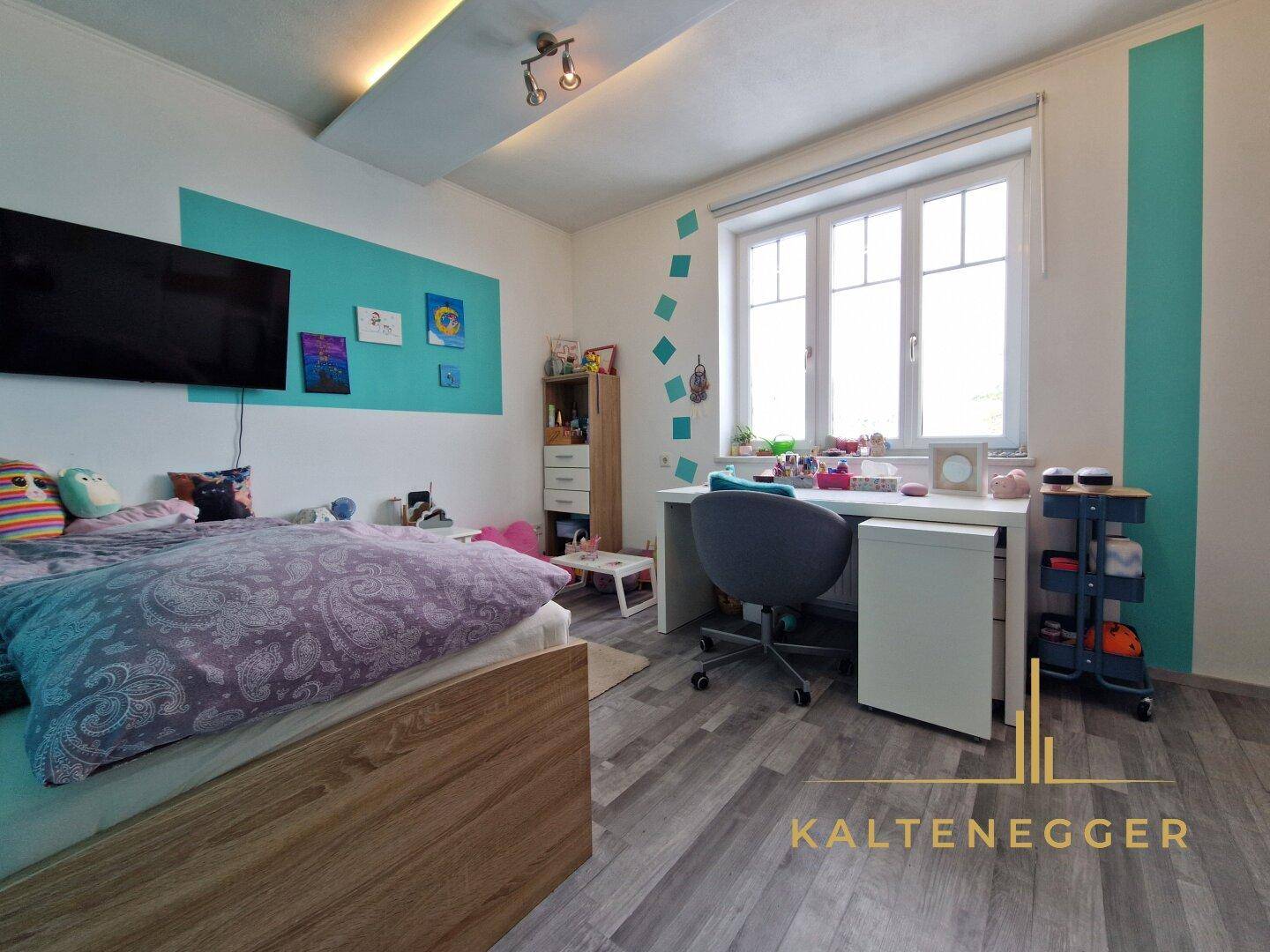 Kinderzimmer mit modernem Boden, Schreibtisch und farbenfroher Wandgestaltung.