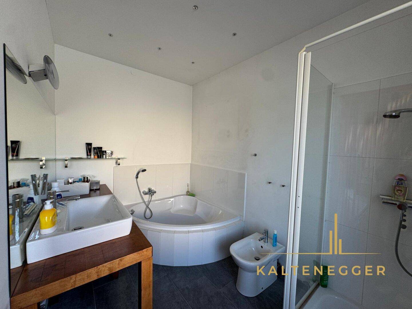 Modernes Badezimmer mit Eckbadewanne, Dusche, Bidet und Doppelwaschbecken.