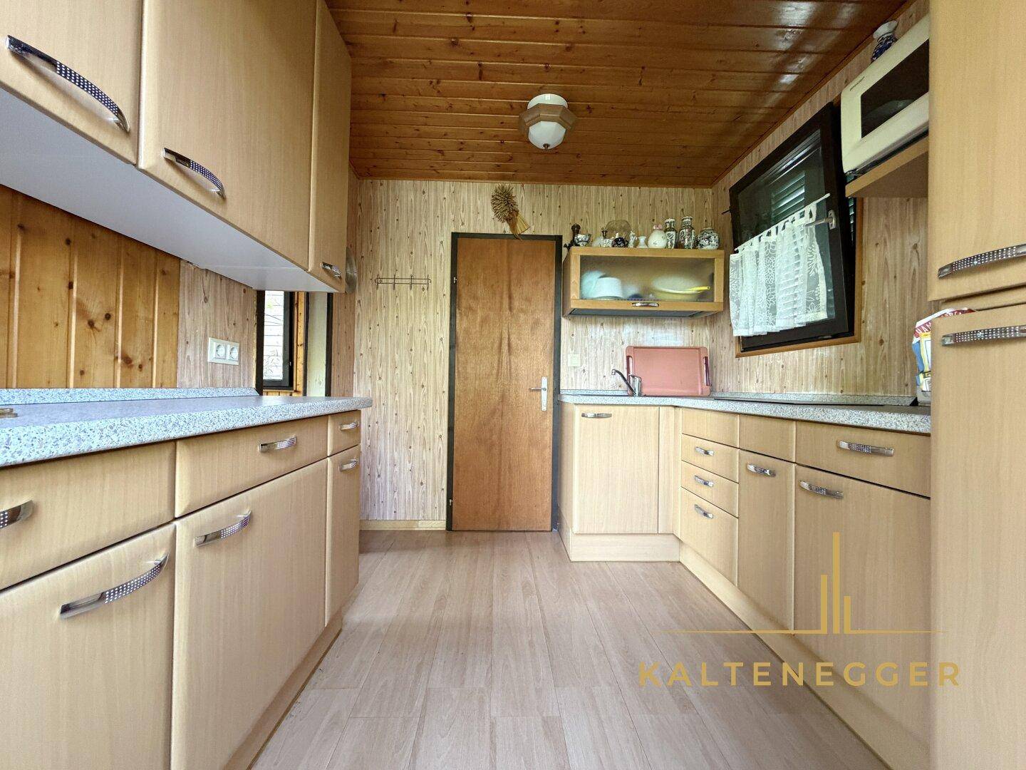 Praktische Küche mit hellen Holzfronten, integrierten Geräten und ausreichend Stauraum.
