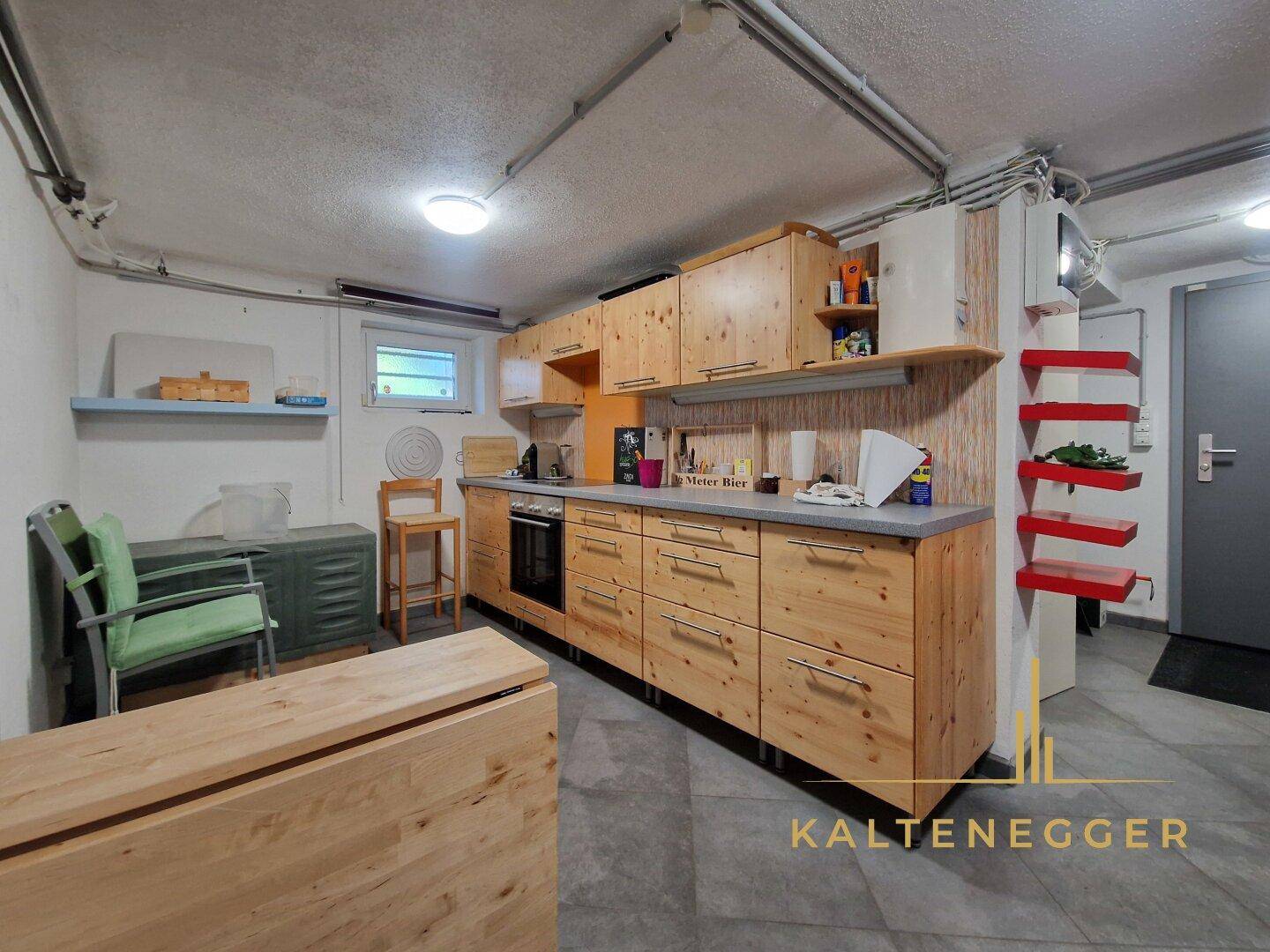 Funktionale Kellerküche mit Holzschränken, Herd und Arbeitsplatte, ideal für Vorräte.