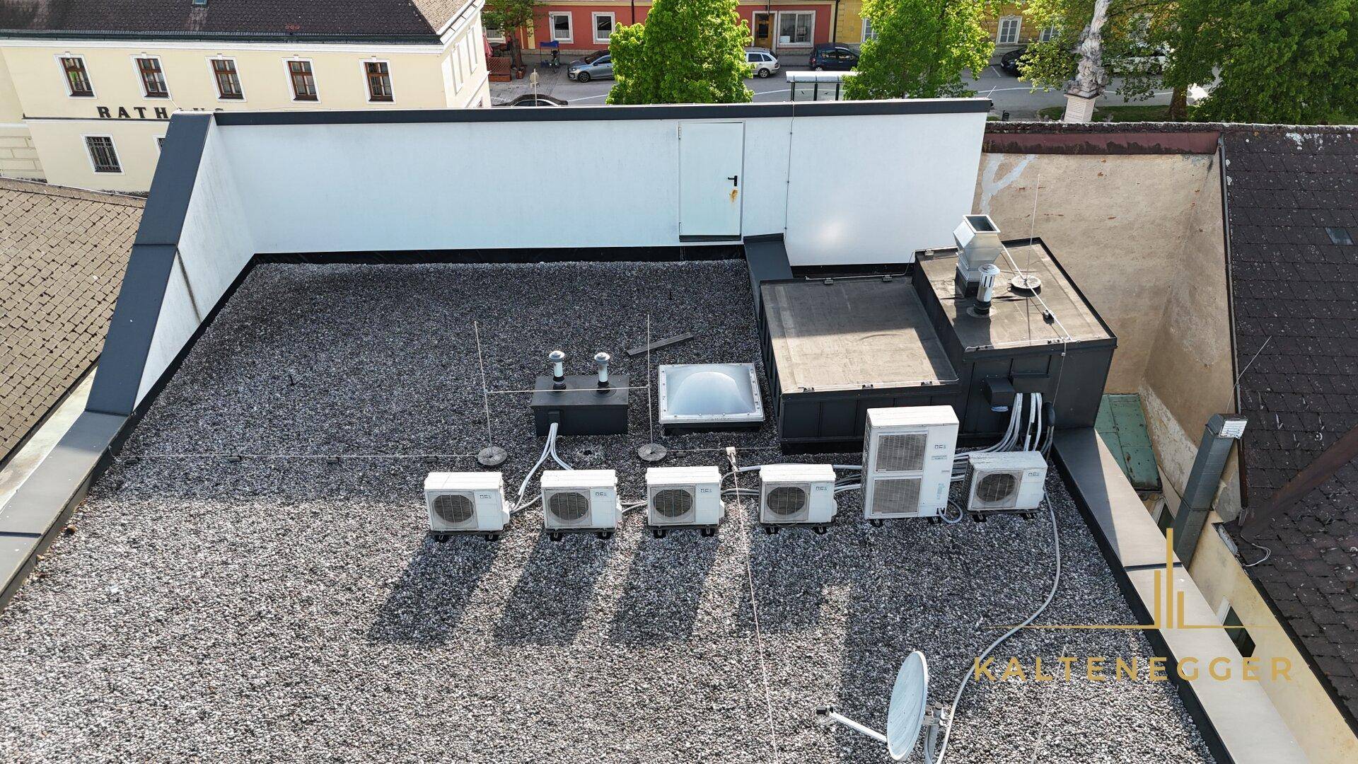 Flachdach des Gebäudes mit zahlreichen Klimaanlagen und Lüftungseinheiten für die Gebäudetechnik.