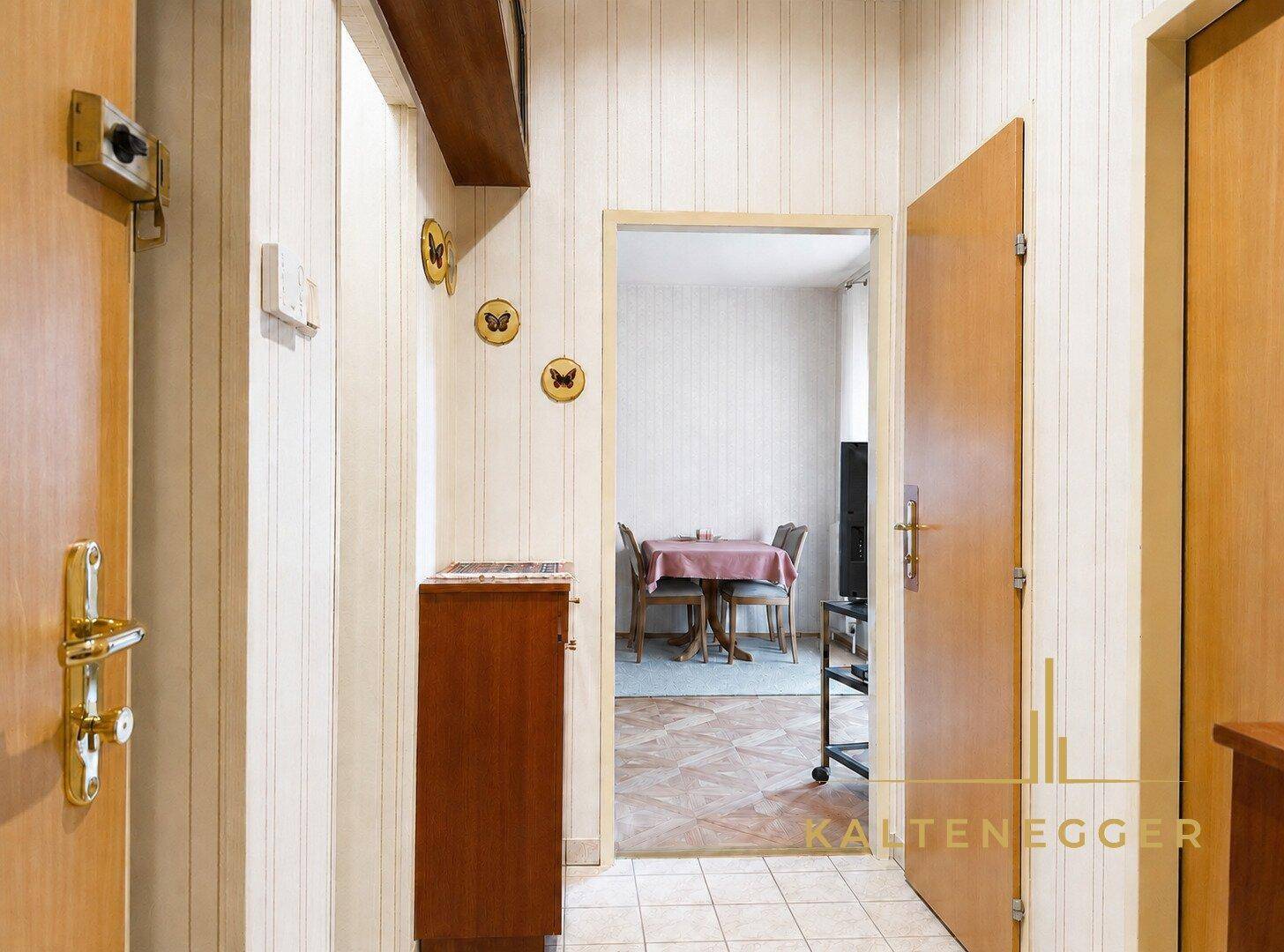Heller Flur mit Holzvertäfelung und Durchgang zum Wohnbereich der Wohnung.