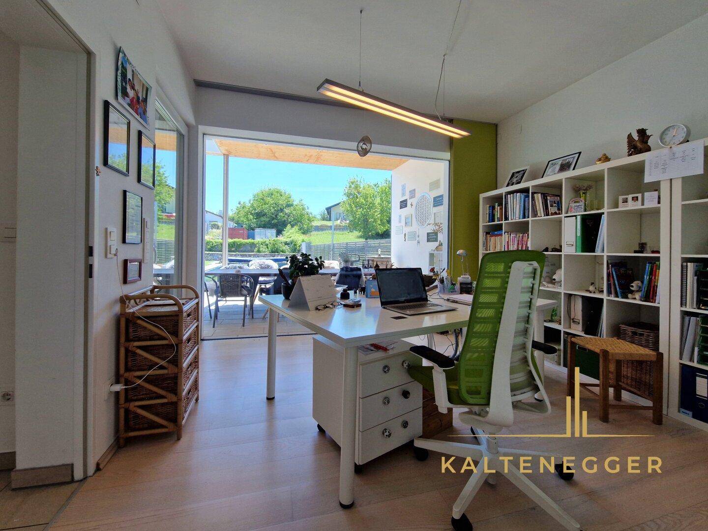 Helles Büro mit großem Schreibtisch, Bücherregalen und direktem Zugang zur Terrasse.