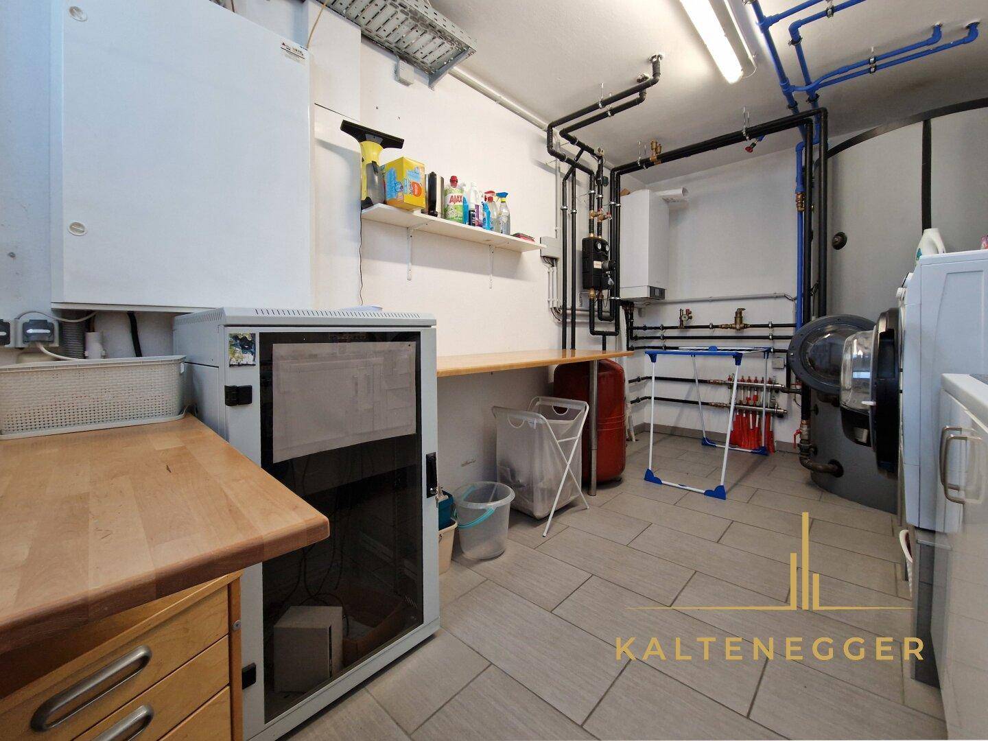 Geräumiger Hauswirtschaftsraum mit Waschmaschine, Trockner und Heizungsanlage.