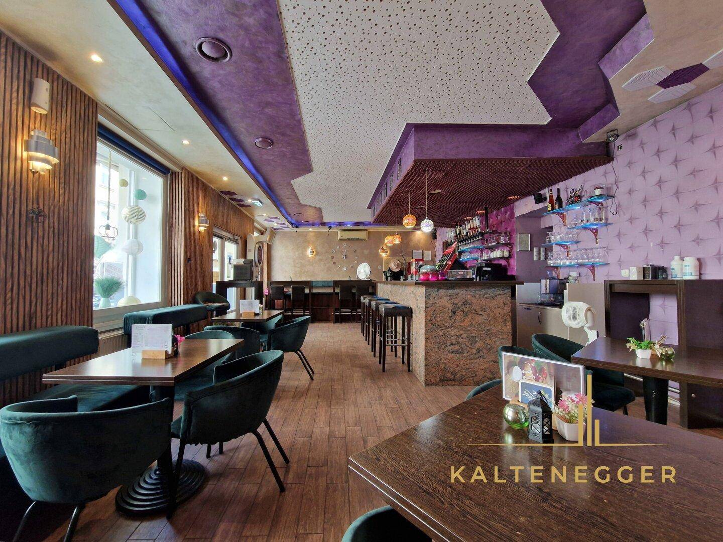 Innenansicht des Barbereichs mit Holzboden, bequemen Sitzgelegenheiten und großen Fenstern zur Straße.