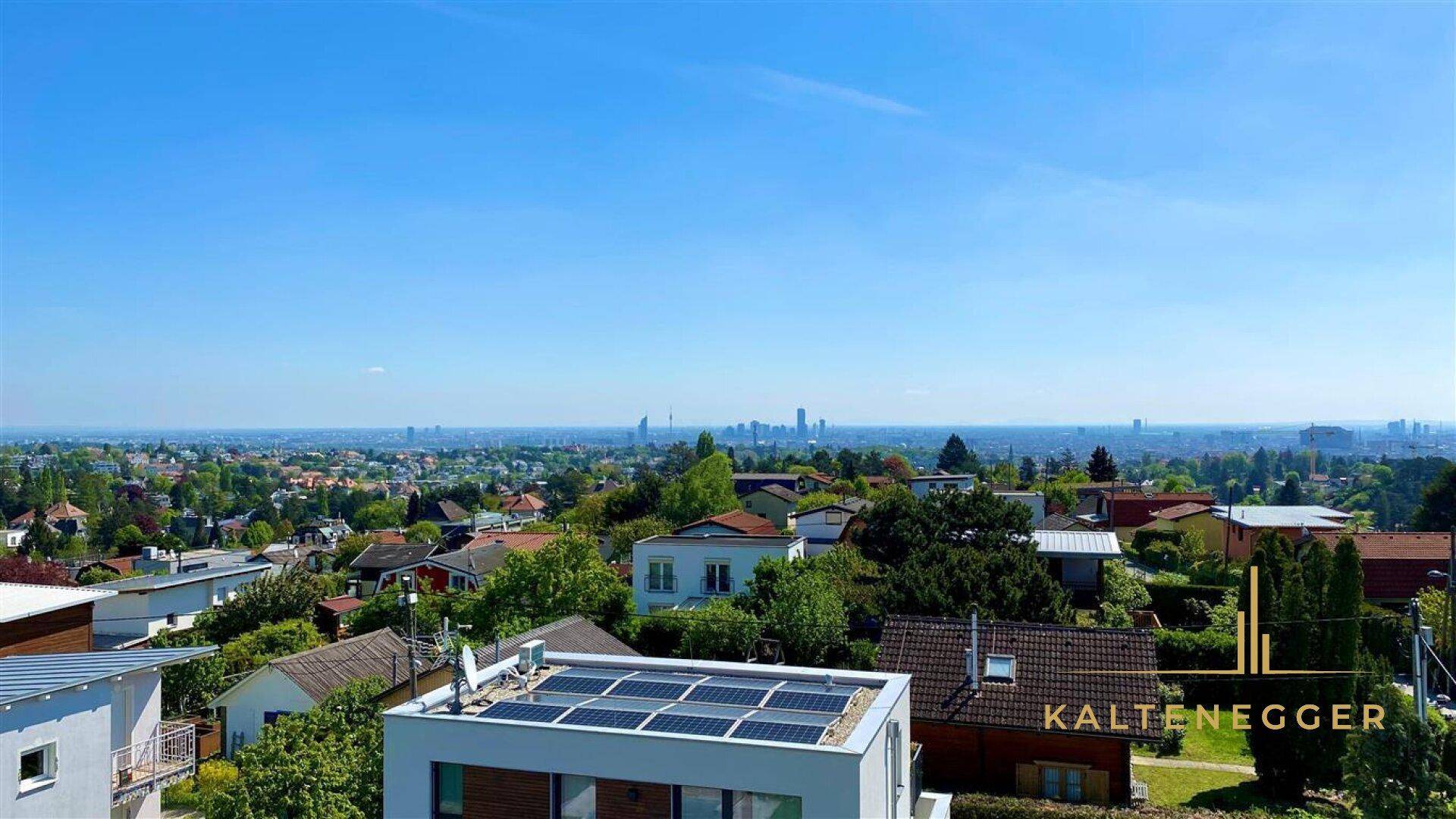 Blick über ein Wohngebiet mit modernen Häusern und Solaranlagen auf den Dächern.