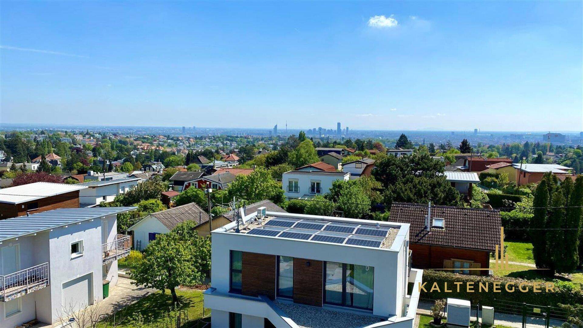 Sonniger Ausblick auf ein Wohnviertel mit modernen Gebäuden und Photovoltaikanlagen auf den Dächern.