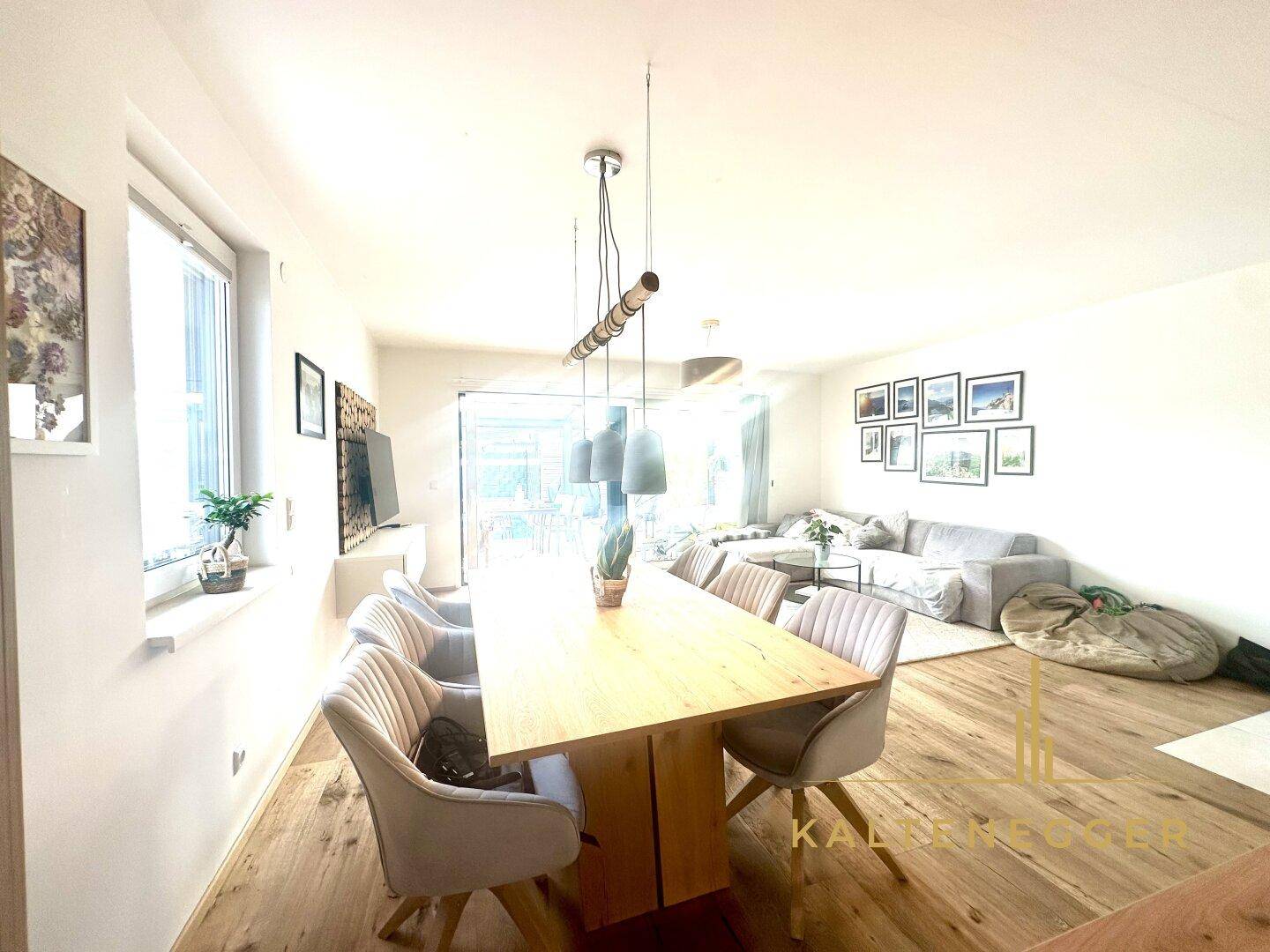 Heller Essbereich mit großem Holztisch und modernen Stühlen, offen zum Wohnzimmer und mit viel Tageslicht.
