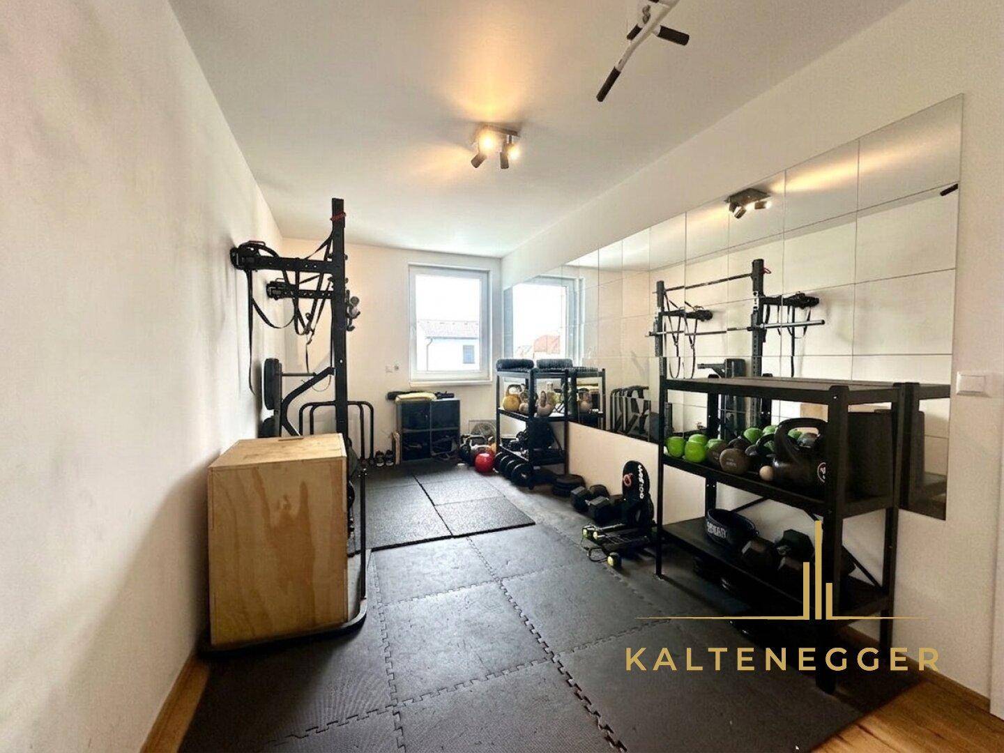 Privater Fitnessraum mit Spiegelfront, Sportgeräten und Gummiboden für das tägliche Training.