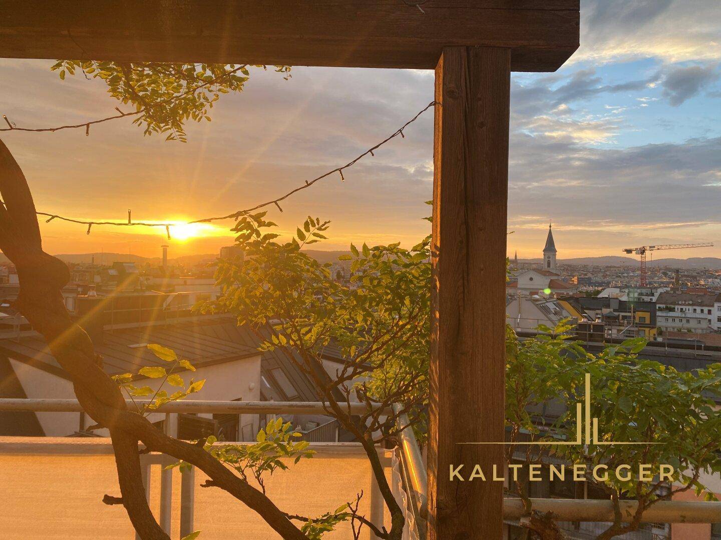 Dachterrasse bei Sonnenuntergang mit Pergola und stimmungsvoller Beleuchtung über der Stadt.