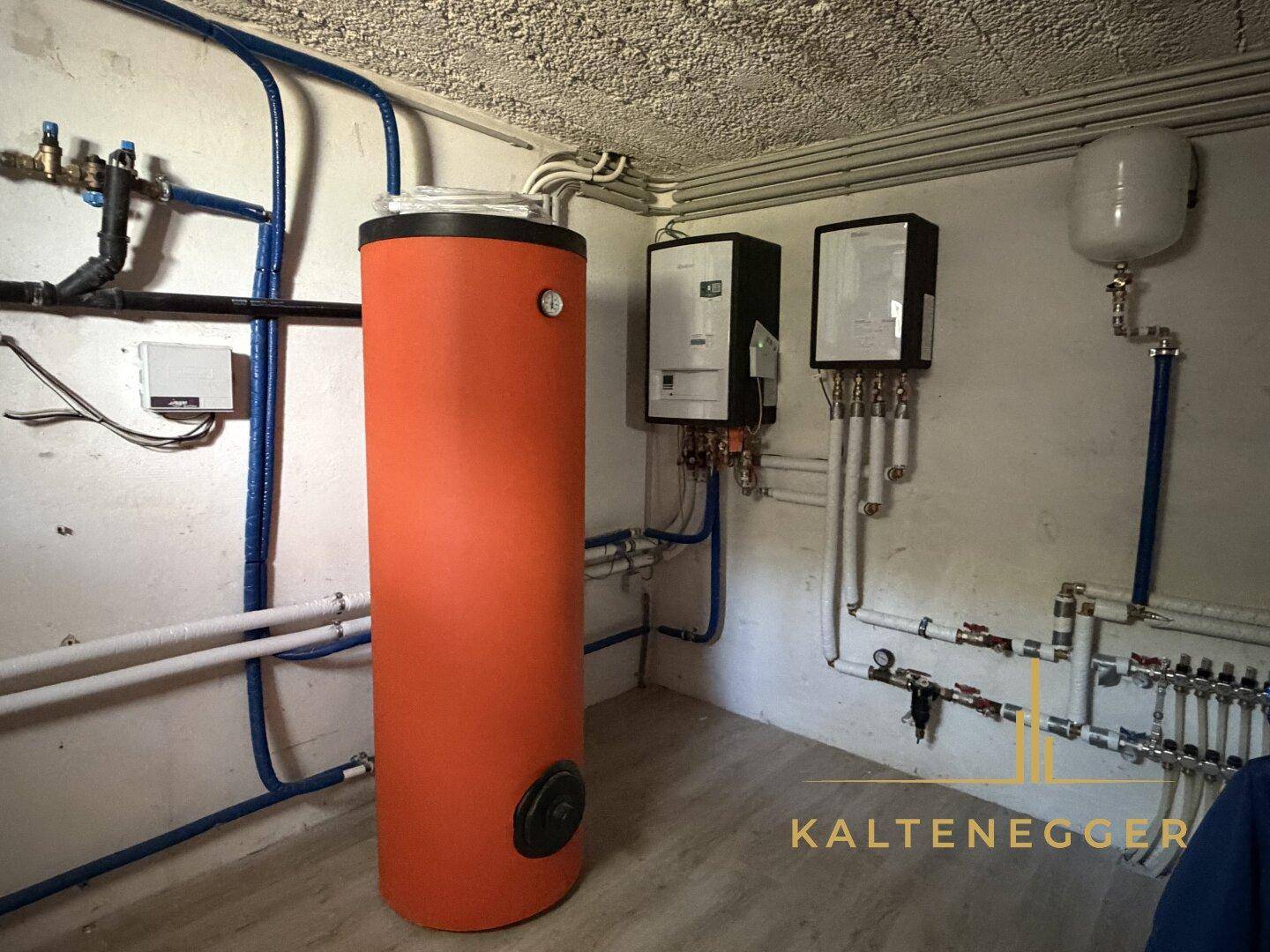 Technikraum im Keller mit Warmwasserspeicher und Heizungsanlage.