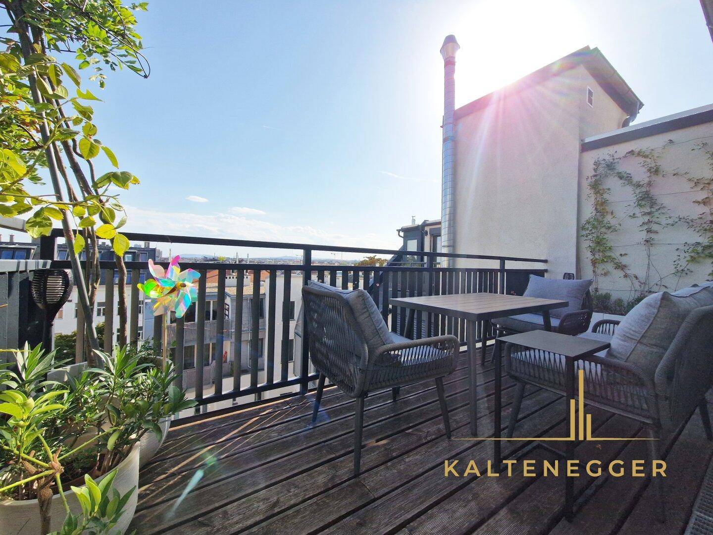 Gemütliche Dachterrasse mit Sitzgelegenheiten, Pflanzen und weitem Blick über die Stadt.