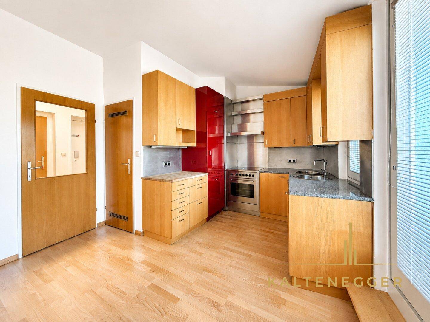 Funktionale Küche mit Holzschränken, Granitarbeitsplatte und integrierten Geräten.
