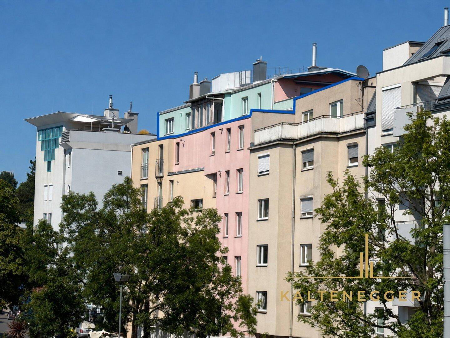 Mehrstöckiges Wohngebäude mit farbenfroher Fassade und Dachgeschosswohnungen.
