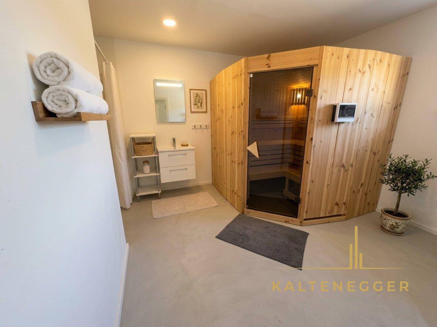 Geräumiges Badezimmer mit integrierter Holzsauna, Waschtisch und Dusche.