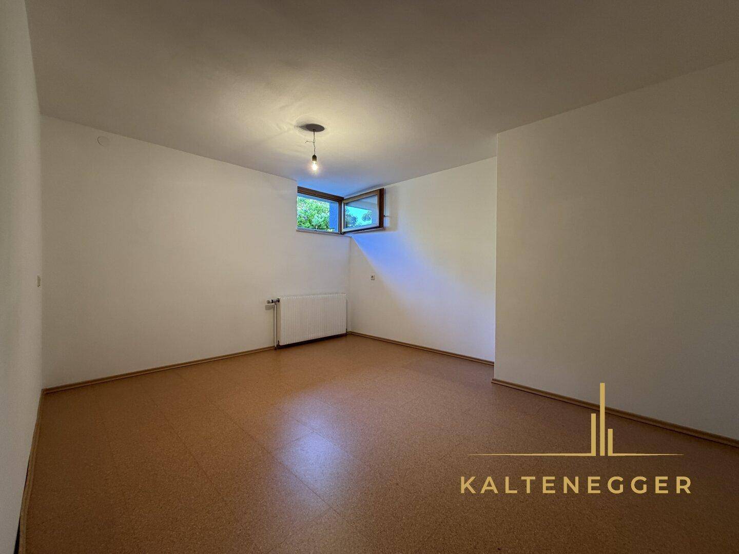 Kellerraum mit robustem Linoleumboden, weißen Wänden und einem kleinen Fenster für Tageslicht.