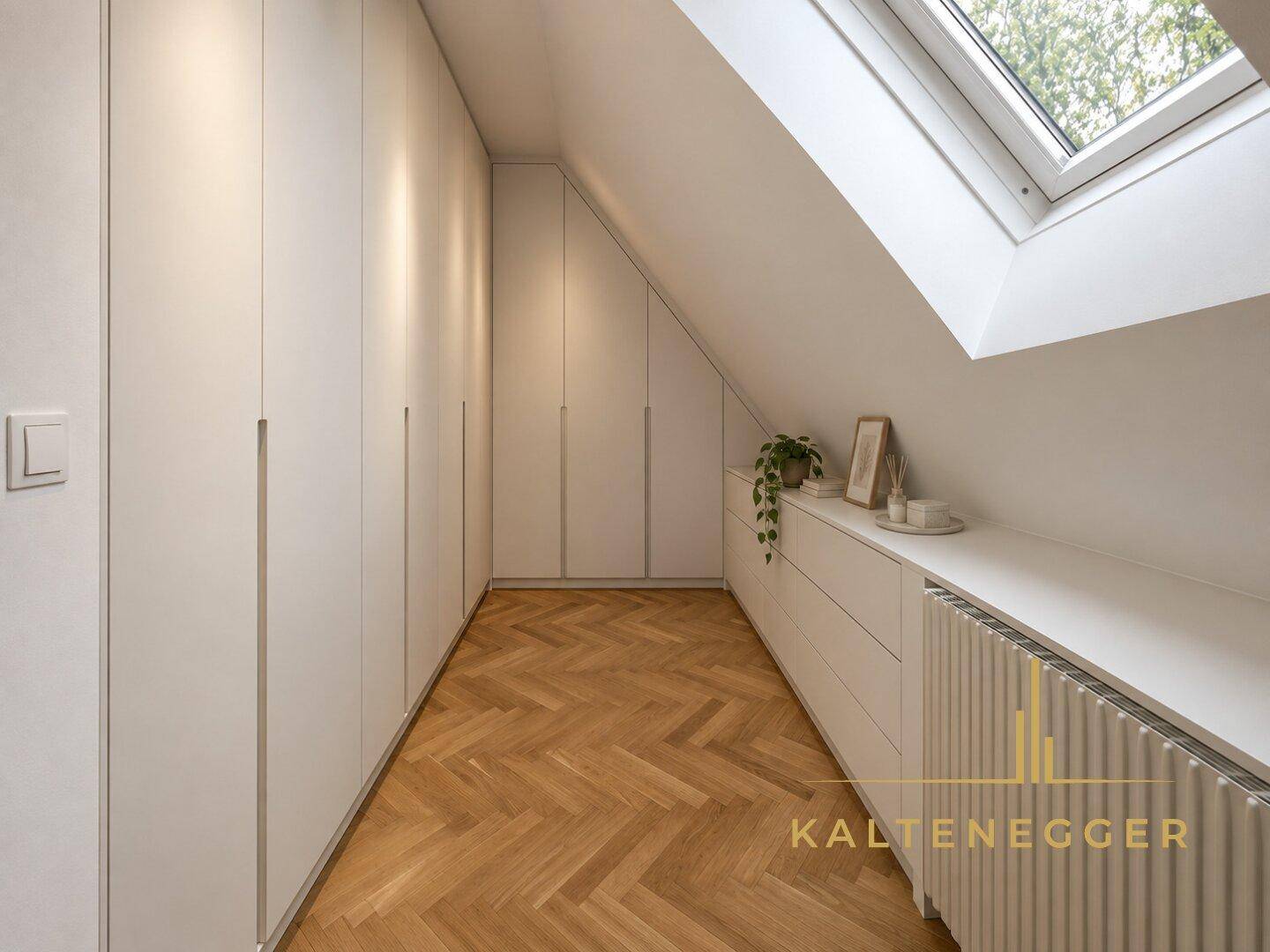 Ankleidezimmer im Dachgeschoss mit Einbauschränken, Fischgrätparkett und Dachfenster.