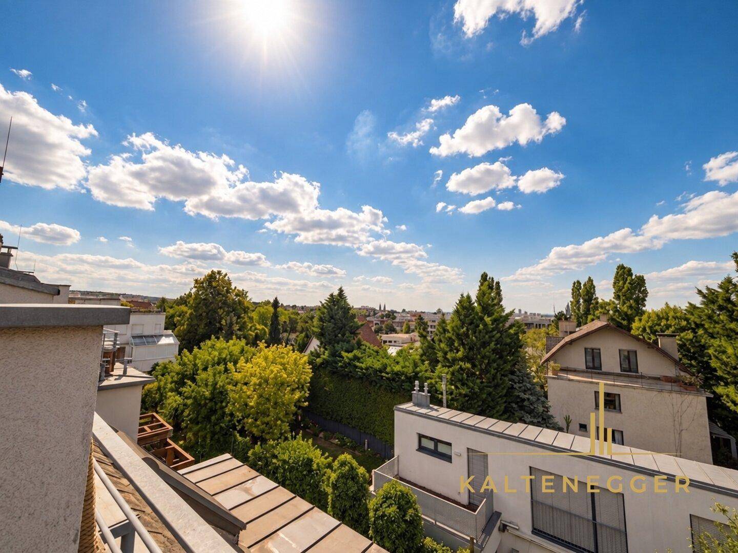 Sonniger Ausblick von einem Balkon über grüne Dächer und Bäume mit Stadtsilhouette am Horizont.