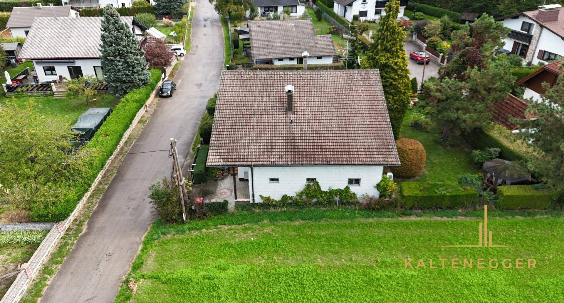 Rückansicht des Einfamilienhauses mit Satteldach und angrenzender Grünfläche.
