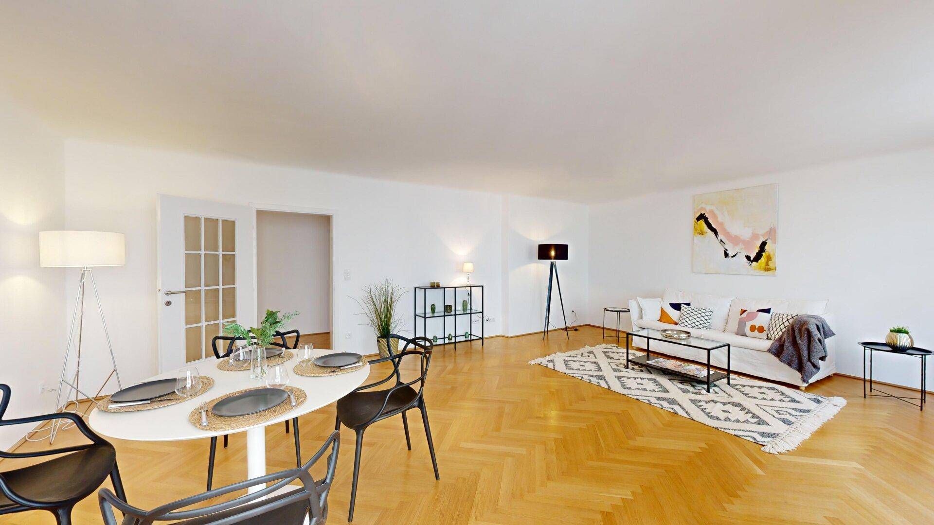 Offener Wohn- und Essbereich mit elegantem Esstisch, bequemer Sitzecke und hellem Parkettboden.