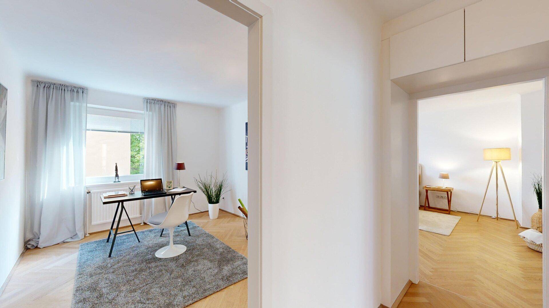 Heller Flur mit Einbauschränken, der zu einem modernen Arbeitszimmer führt.