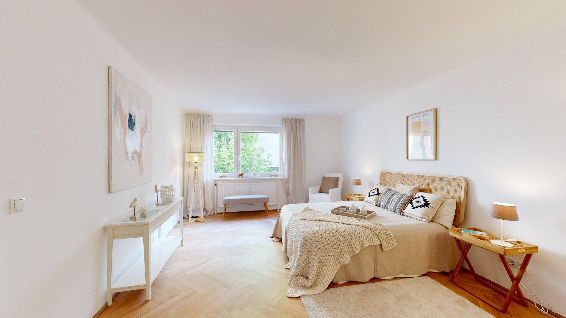 Helles Schlafzimmer mit Fischgrätparkett, bequemen Bett und stilvoller, minimalistischer Dekoration.