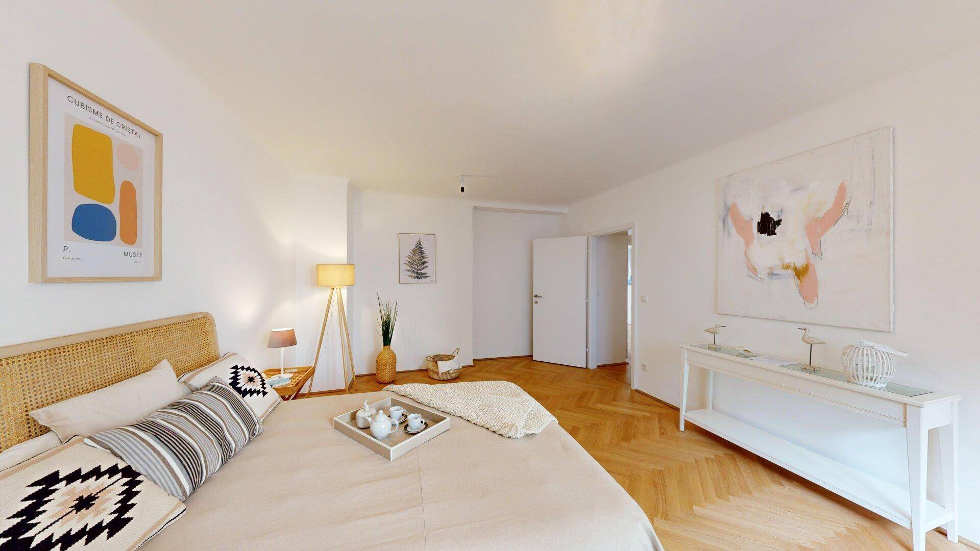 Einladendes Schlafzimmer mit Fischgrätparkett und moderner Einrichtung, ideal zum Entspannen.