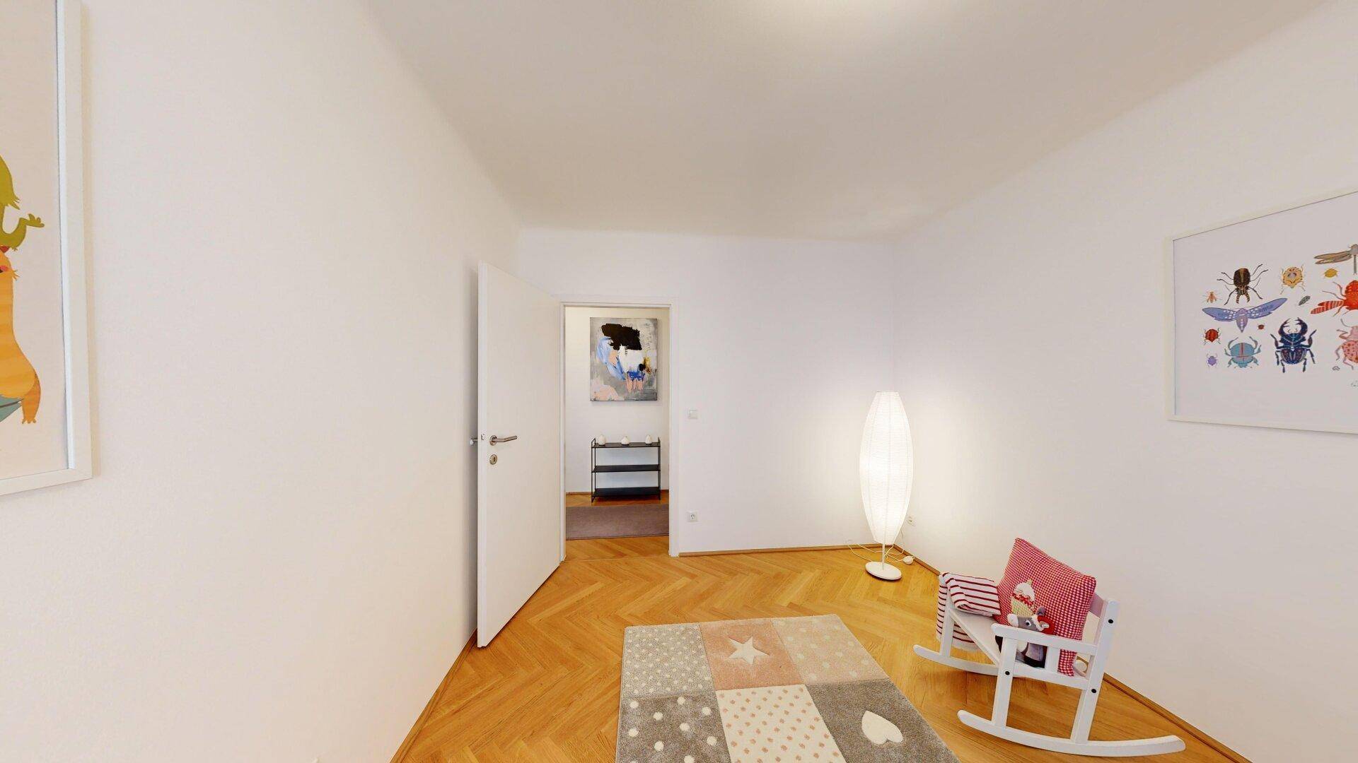 Helles Kinderzimmer mit Fischgrätparkett und spielerischer Dekoration, ideal für kleine Bewohner.