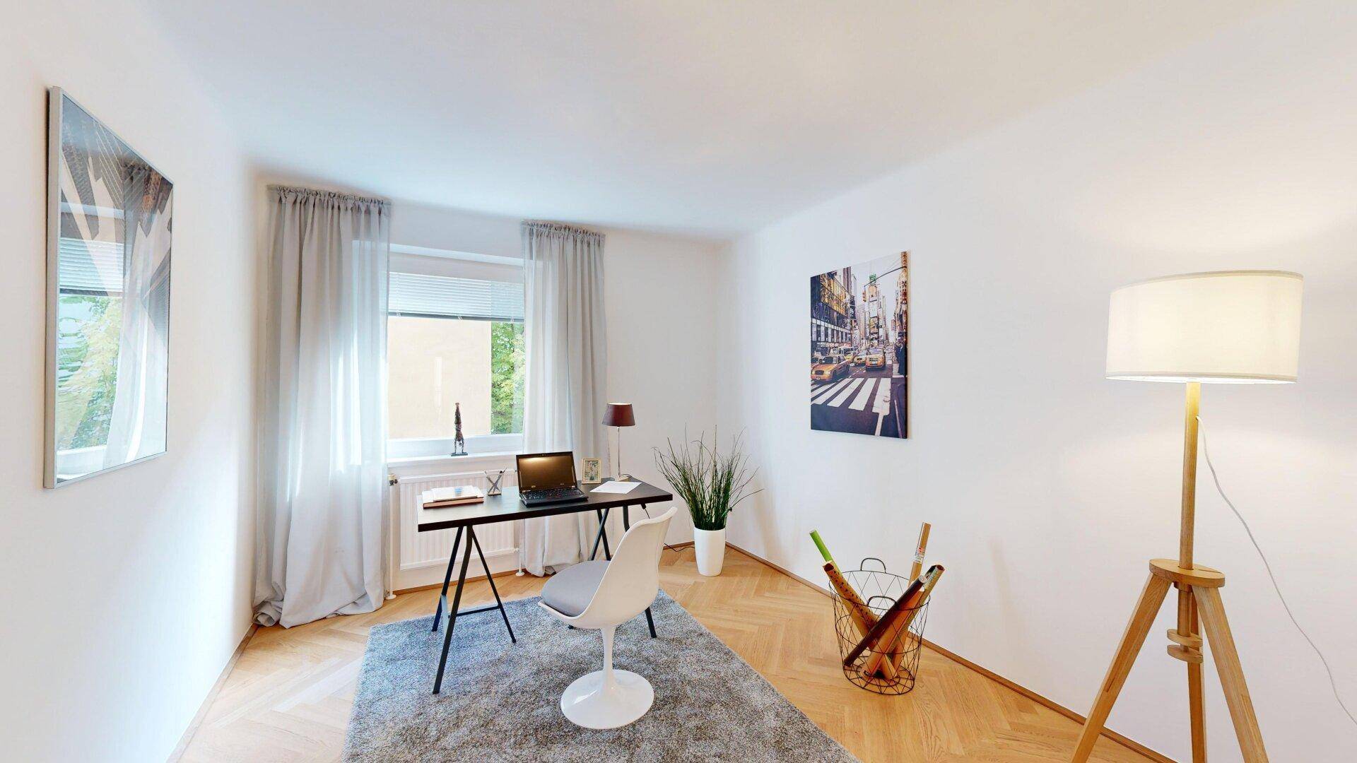 Modernes Arbeitszimmer mit Fischgrätparkett, Schreibtisch und großem Fenster für viel Tageslicht.