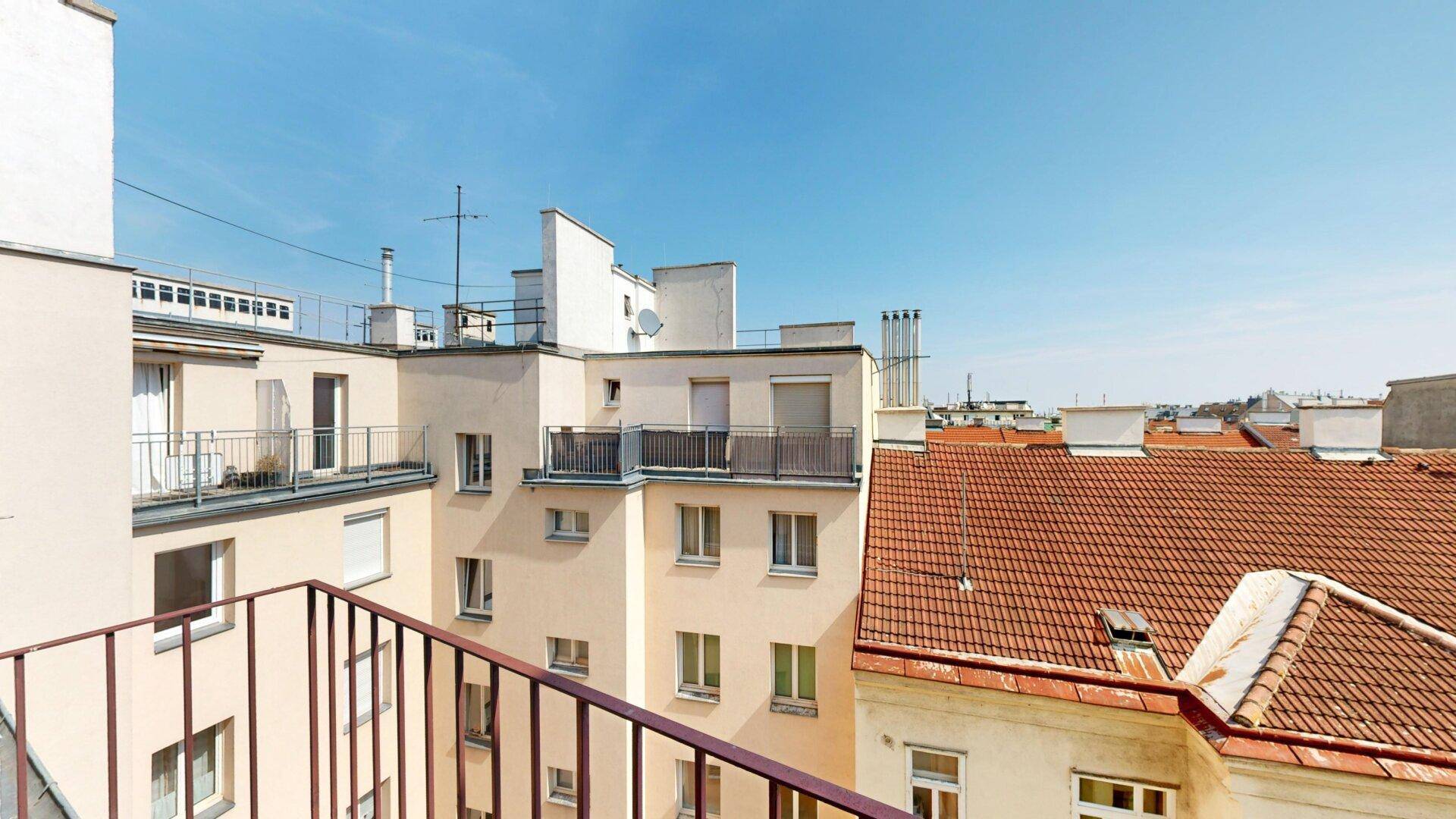 Panoramablick von einem Balkon über die umliegenden Gebäude und Dächer der Stadt.