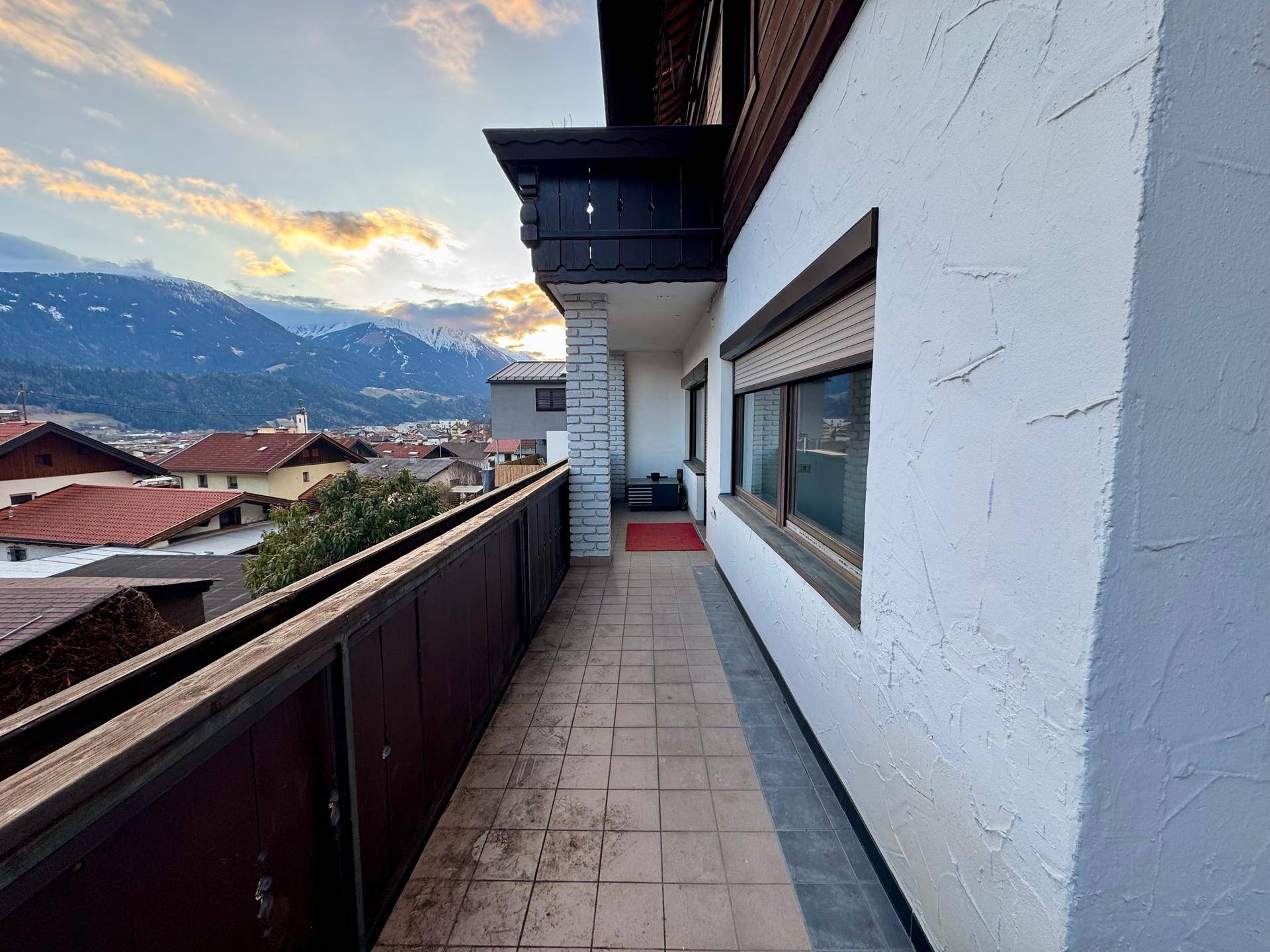 Geräumiger Balkon mit Bergblick und Rollläden an den Fenstern, ideal für entspannte Stunden im Freien.