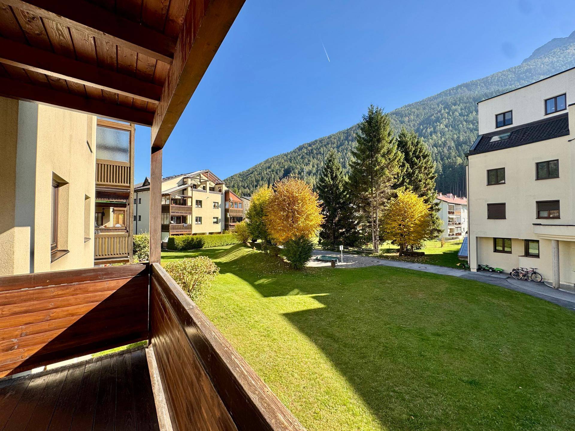 Balkon mit weitem Blick auf grüne Wiesen und die umliegenden Berge.