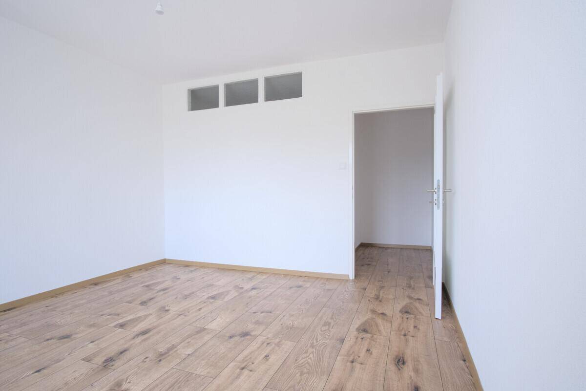 Heller Raum mit Holzboden und weiß gestrichenen Wänden, bietet vielseitige Nutzungsmöglichkeiten.