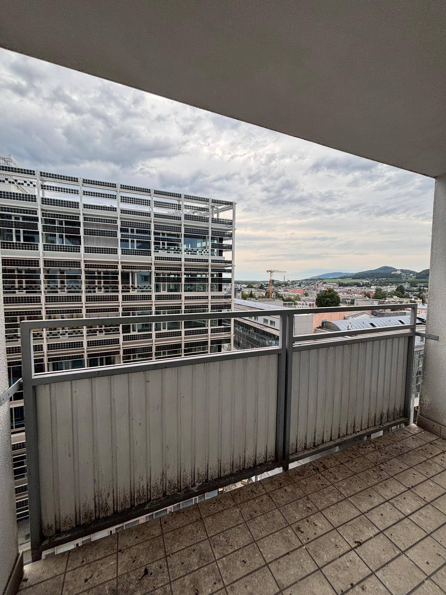 Balkon mit Metallgeländer und Blick auf die Fassade eines modernen Gebäudes.