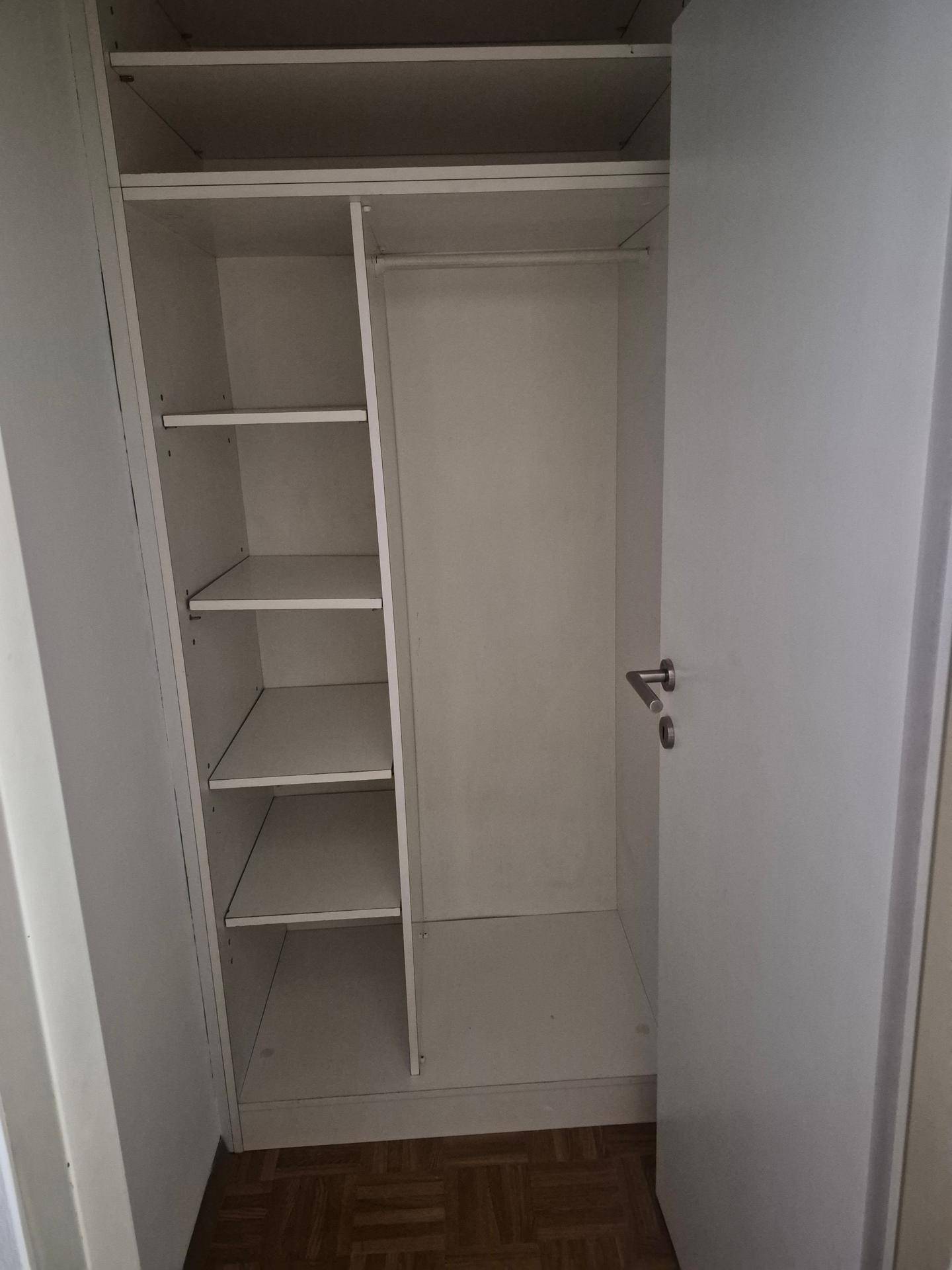 Eingebauter Wandschrank mit Regalen und Stauraum für Kleidung oder Haushaltsgegenstände.