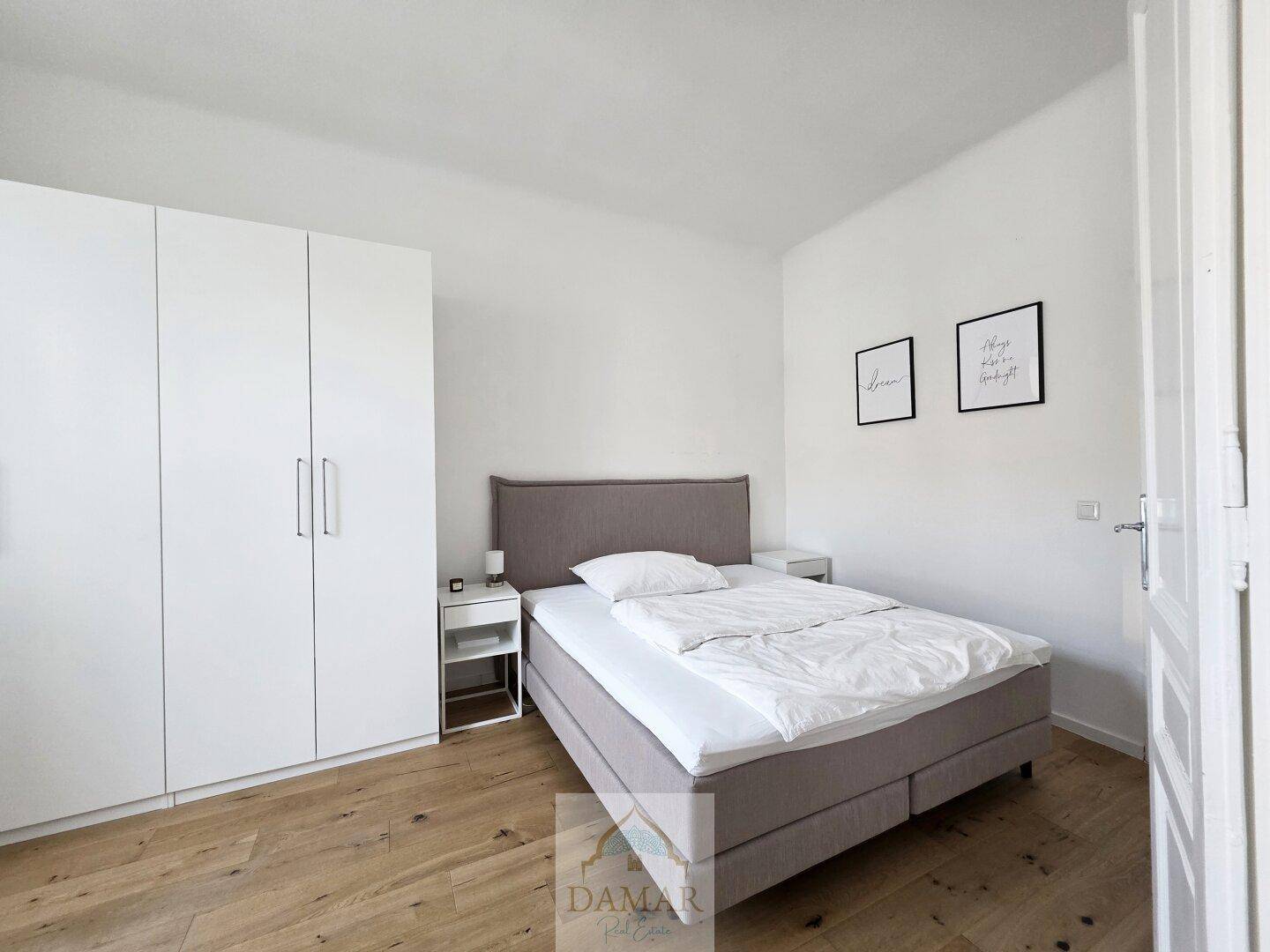 Gemütliches Schlafzimmer mit Doppelbett, weißen Einbauschränken und hellem Holzboden für Komfort.