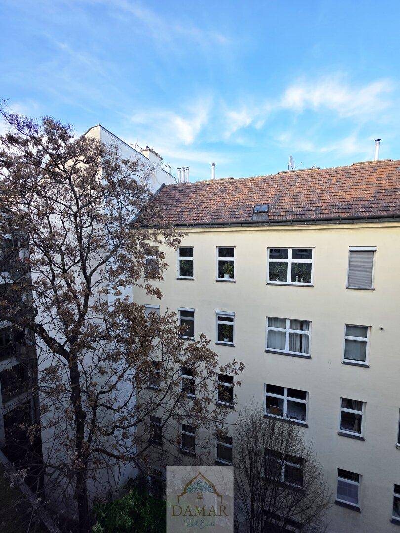 Ansicht einer Gebäudefassade von oben mit mehreren Fenstern und einem traditionellen Ziegeldach.