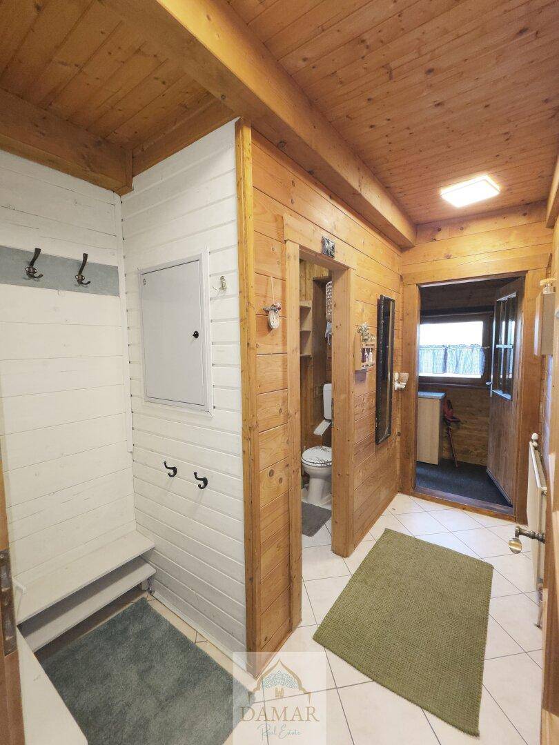 Eingangsbereich mit Garderobe, Fliesenboden und Zugang zu einem separaten WC.