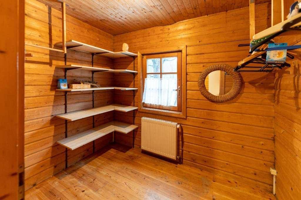 Praktischer Abstellraum mit Holzvertäfelung, eingebauten Regalen und einem kleinen Fenster.