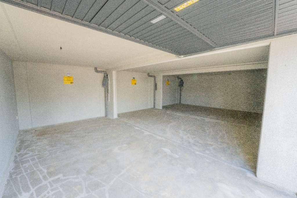 Leere Tiefgarage mit Betonboden und grauer Deckenkonstruktion, bereit zur Nutzung als Stellplatz.